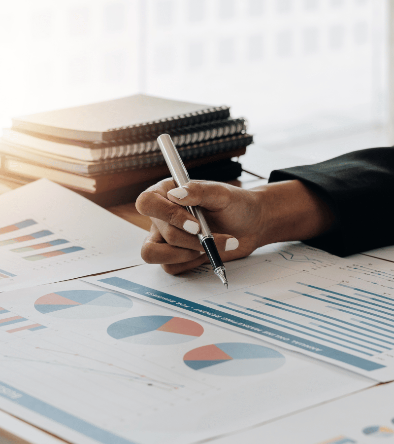 Financial reports, charts, and writing materials on a desk